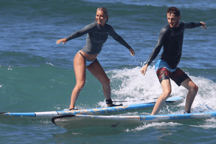a young girl riding a wave on a surfboard in the water