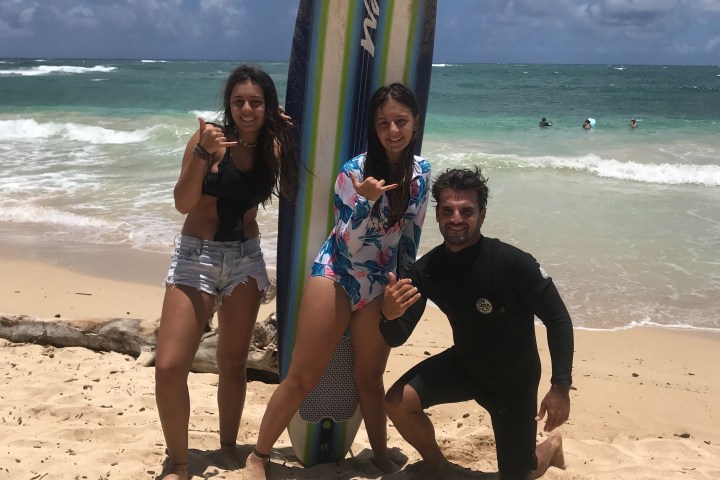a couple of people that are standing in the sand on a beach