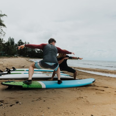 a man sitting on top of a sandy beach