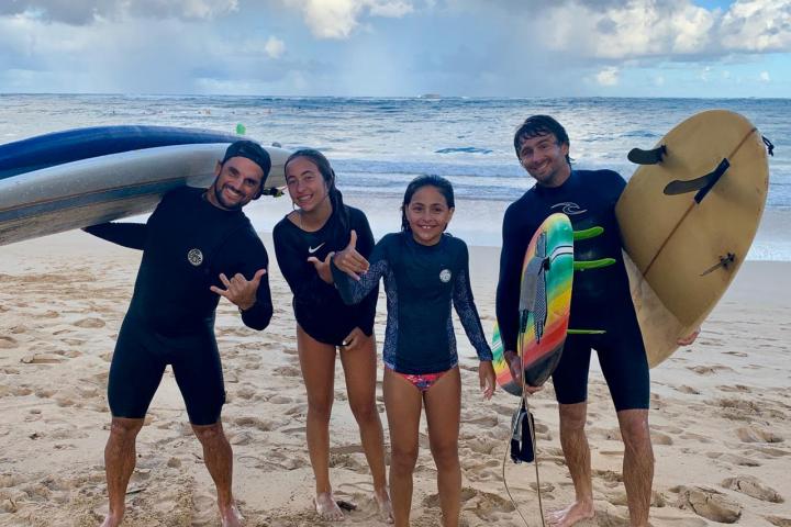 a group of people standing on top of a sandy beach