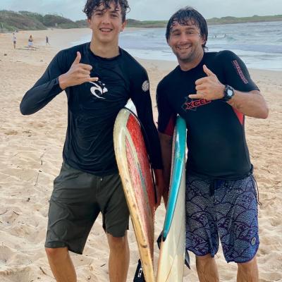 a man standing on a beach holding a fish