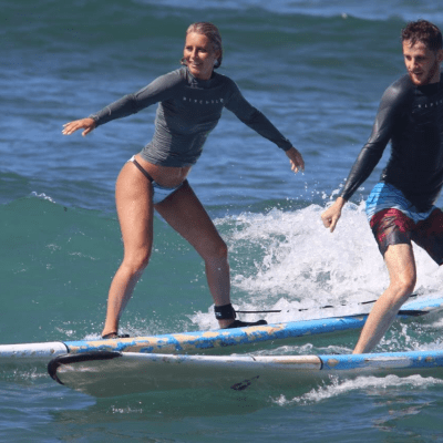 a young girl riding a wave on a surfboard in the water