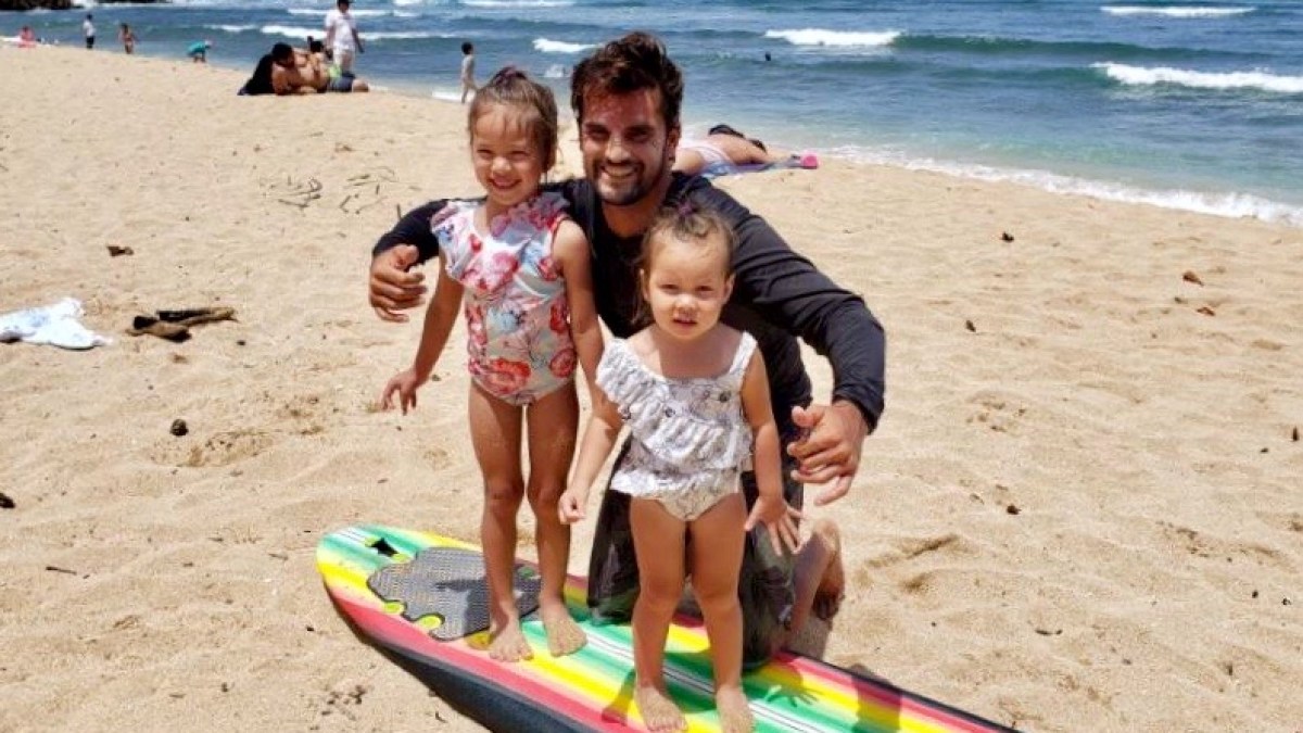 a girl sitting on a sandy beach
