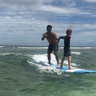 a young girl riding a wave on a surfboard in the ocean
