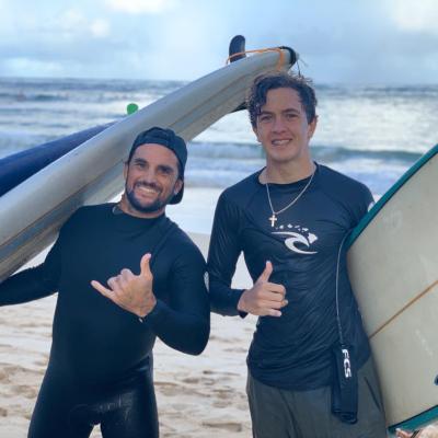 a person wearing a wet suit standing on a beach posing for the camera